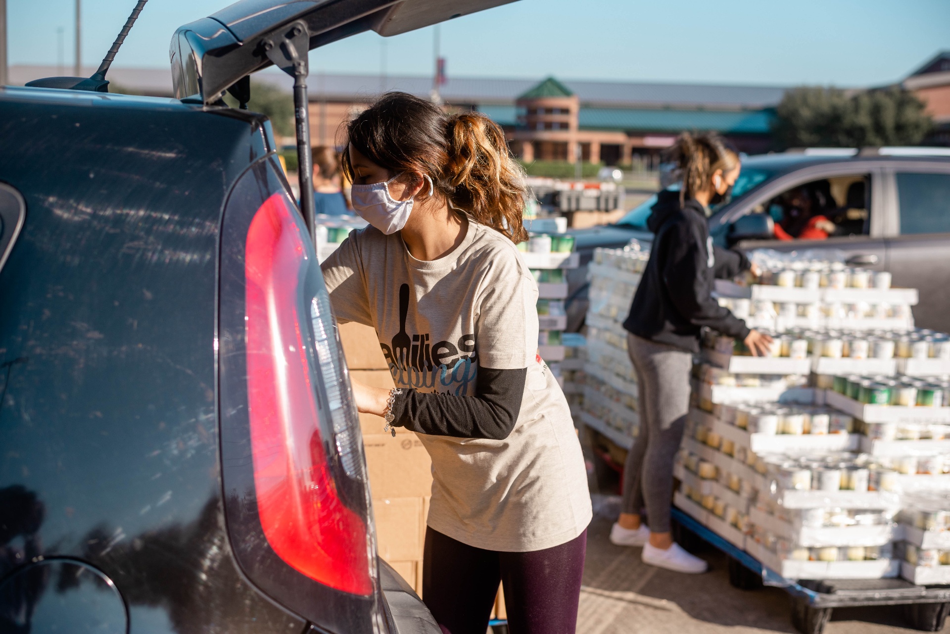 Volunteer loading food boxes into car