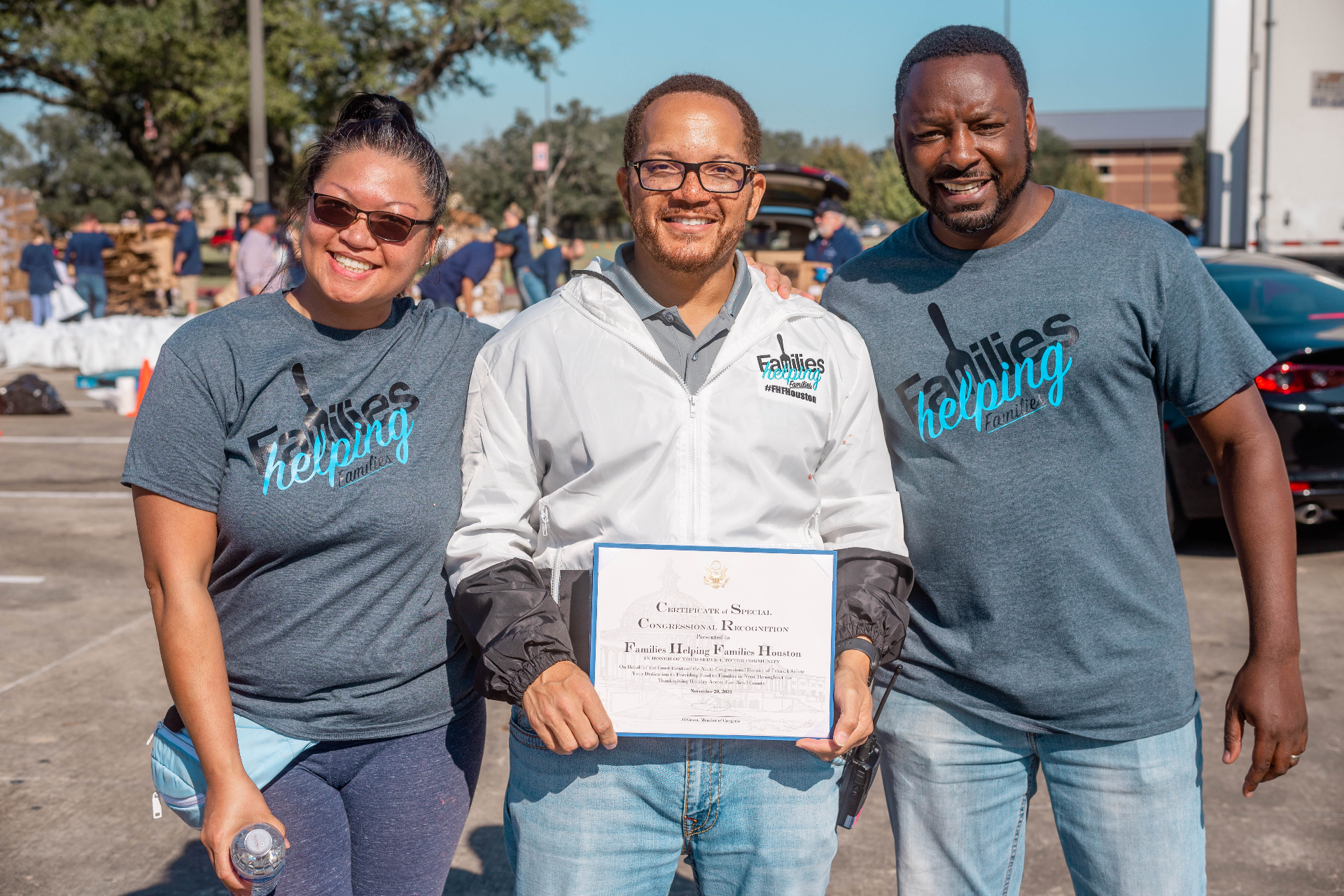Three volunteers with recognition certificate