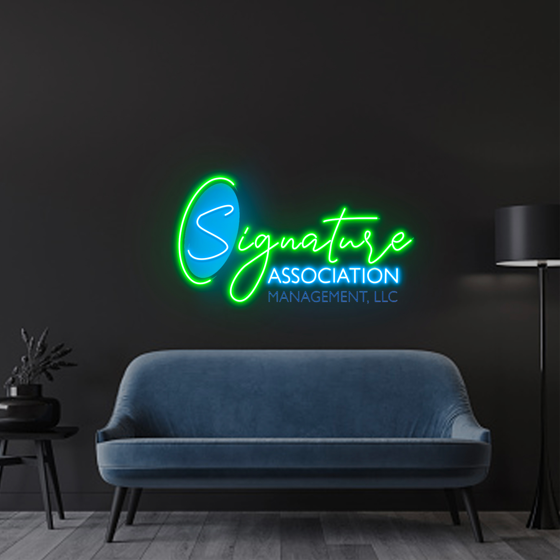 Blue and green illuminated Signature Association wall sign above a blue sofa in a dark office.
